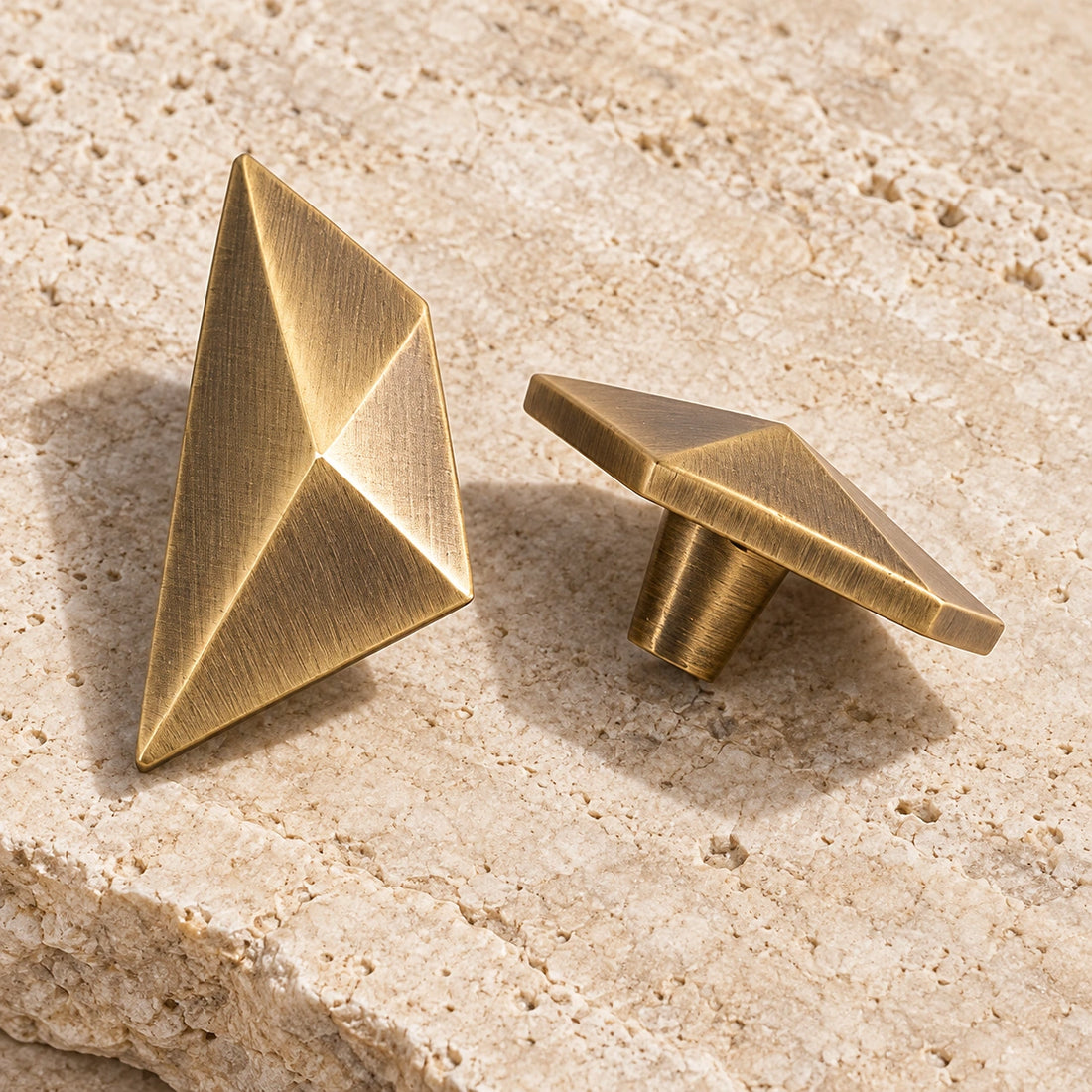Antique brass faceted geometric cabinet knobs on limestone