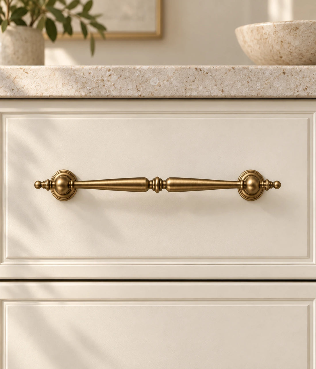 Antique Brass Finial Cabinet Pulls, Pendant Pulls & Knob arranged on pale limestone, showing the brushed brass finish and hardware details