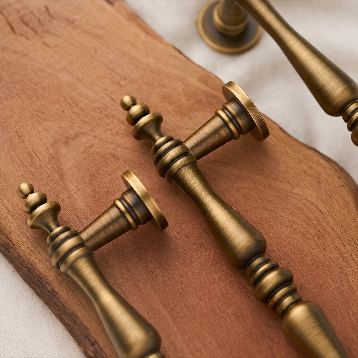 Turned double-spindle grip and layered finial detail in antique brass