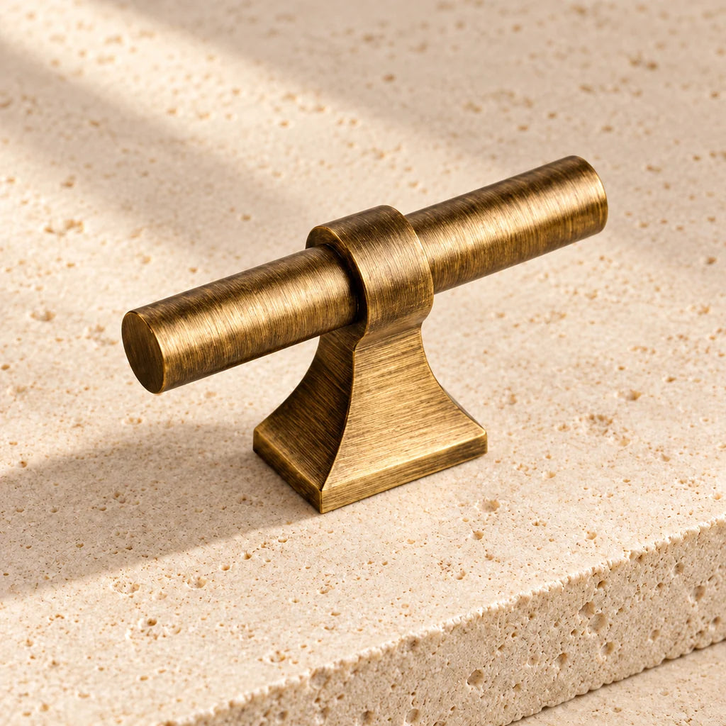 antique brass flared base t knob limestone on pale limestone.