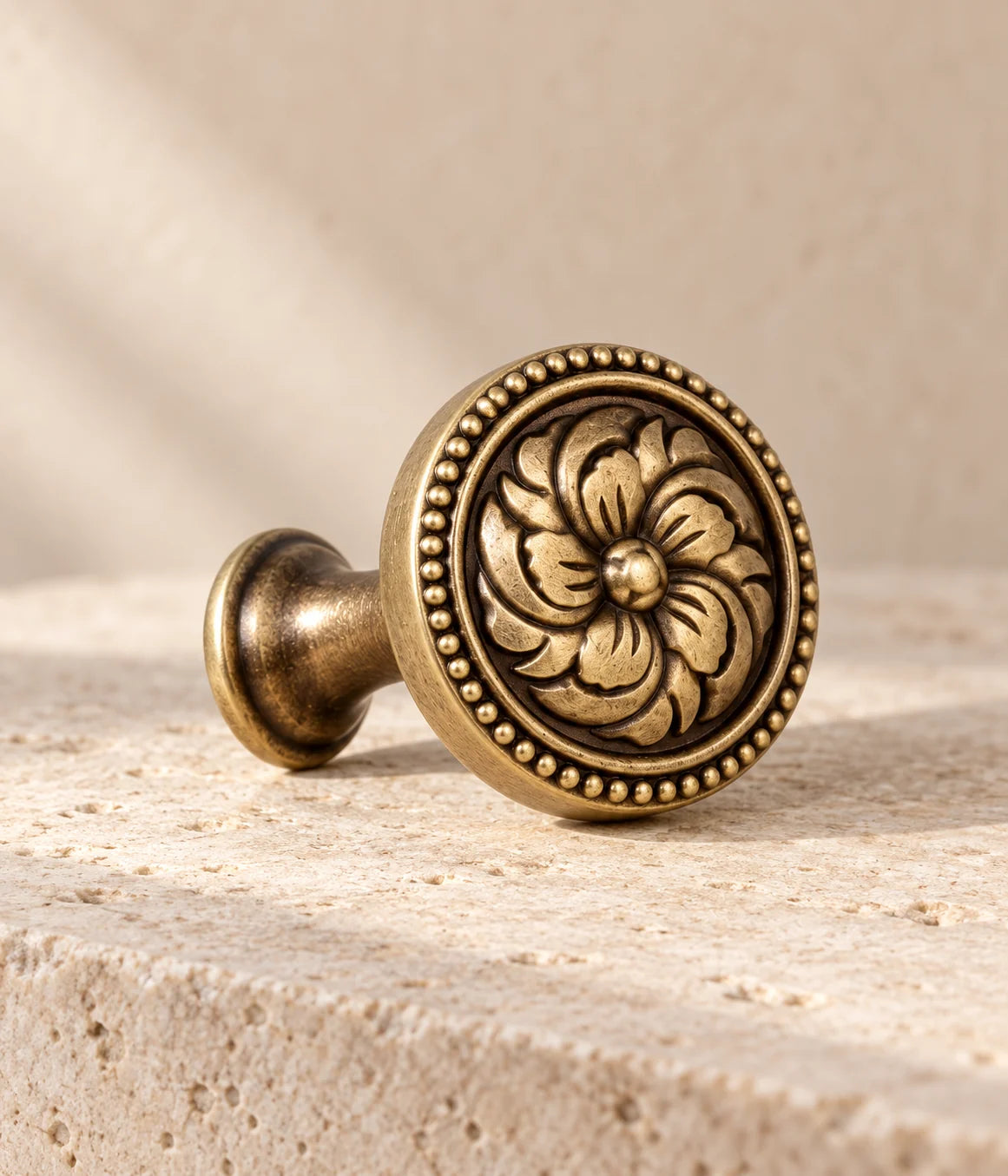 Close view of the raised flower and beaded edge on a solid brass cabinet knob