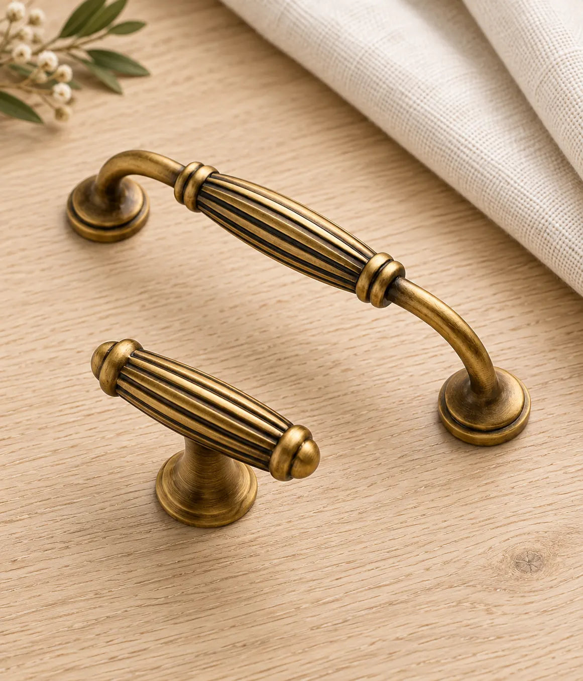 Fluted antique brass cabinet pull and T-knob on pale oak and linen