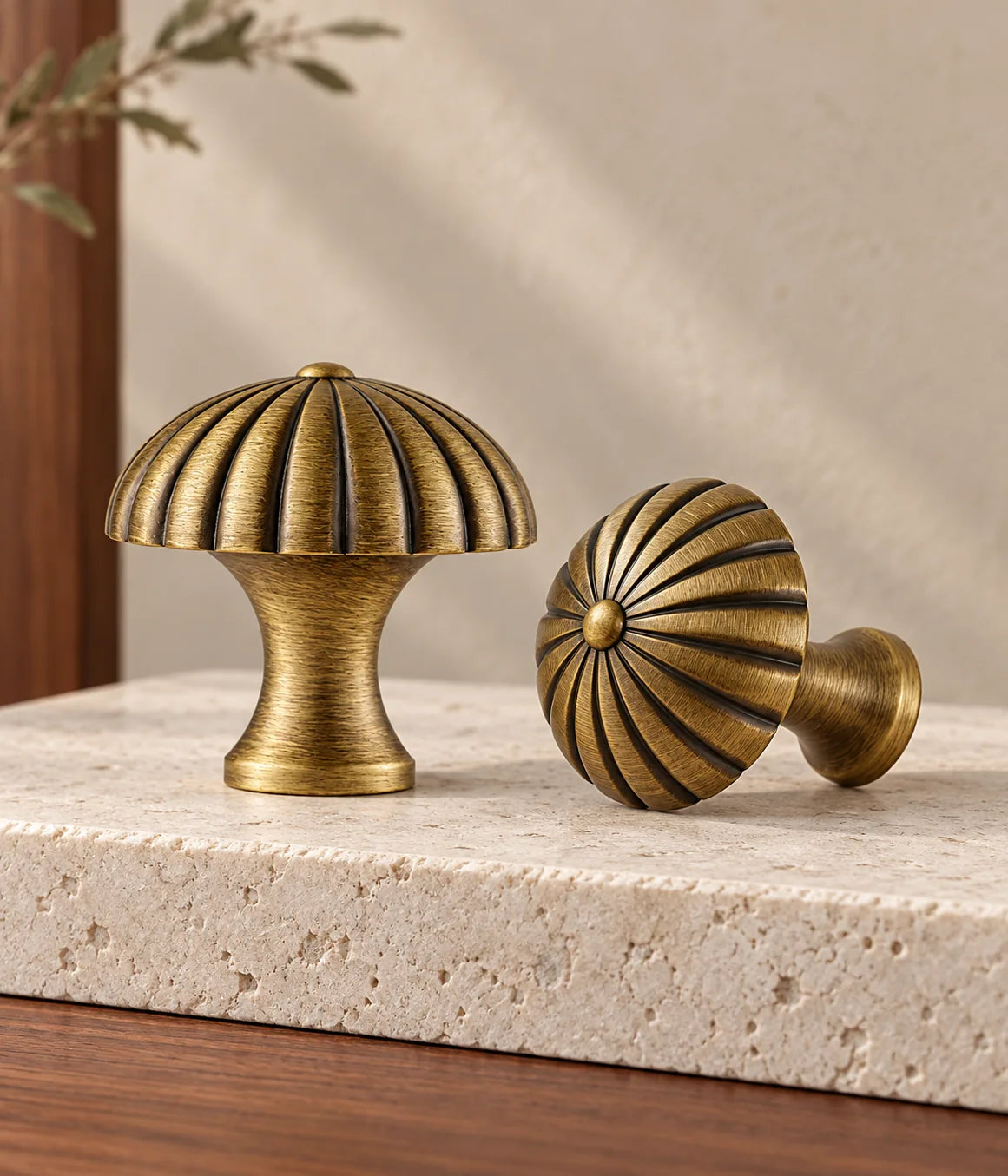 Antique brass fluted canopy cabinet knobs on pale limestone with walnut and warm neutral background