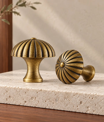 Antique brass fluted canopy cabinet knobs on pale limestone with walnut and warm neutral background