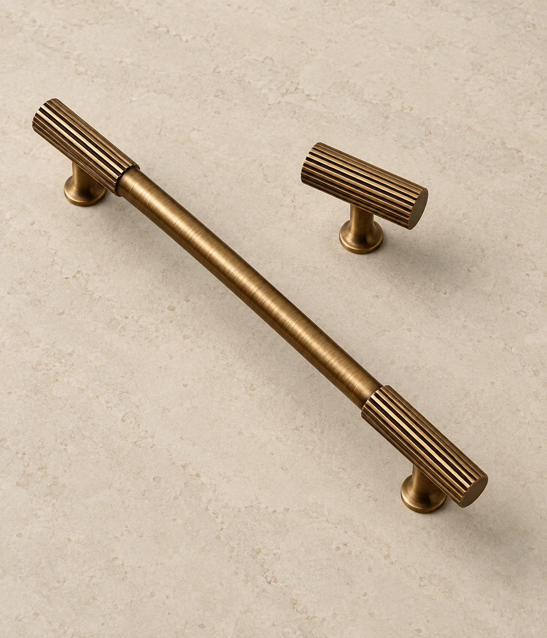 Antique Brass Fluted End Cabinet Pulls & Knobs on warm limestone