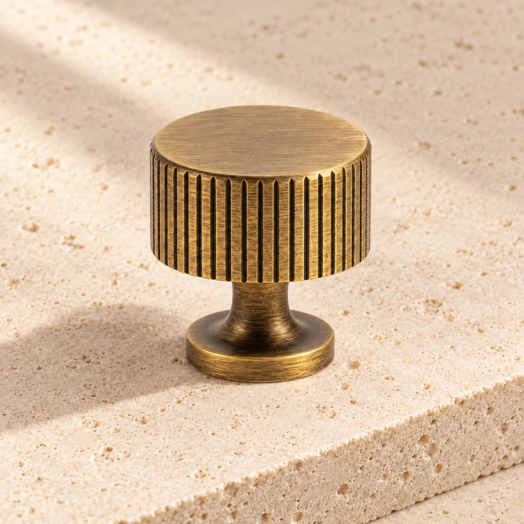 antique brass fluted end knob limestone on pale limestone.