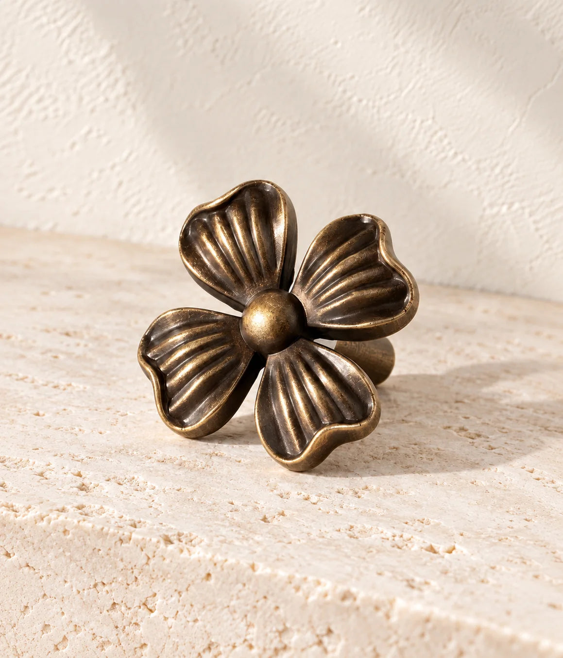 Close view of four fluted petals and rounded center on an antique brass cabinet knob