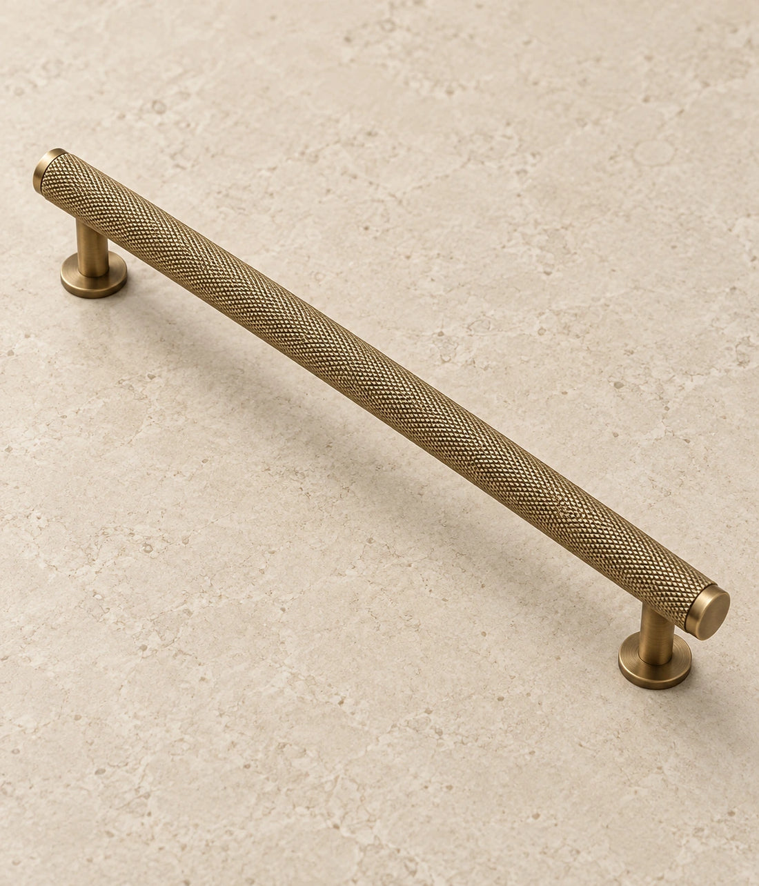 Antique Brass Full Knurled Cabinet Bar Pulls on warm limestone