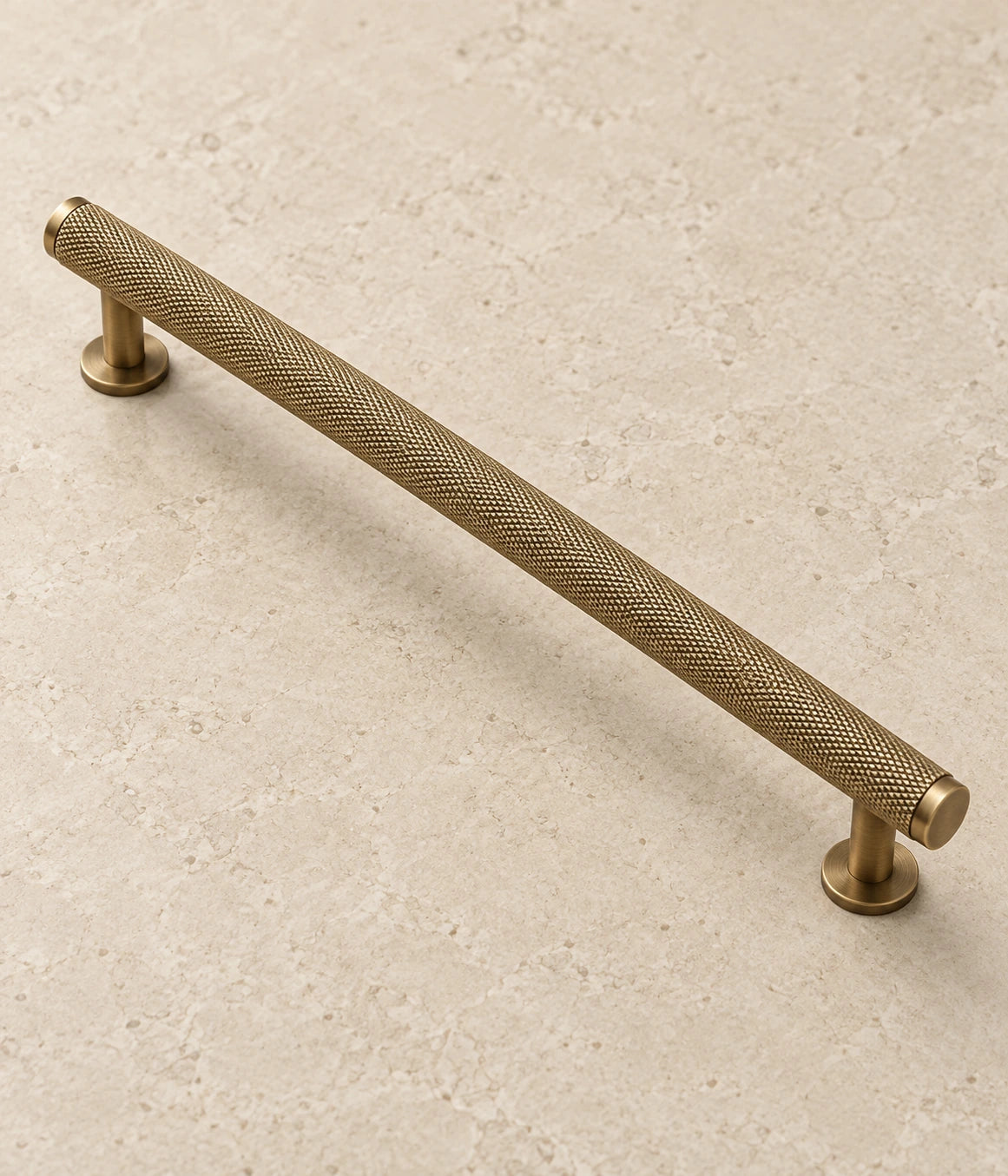 Antique Brass Full Knurled Cabinet Bar Pulls on warm limestone