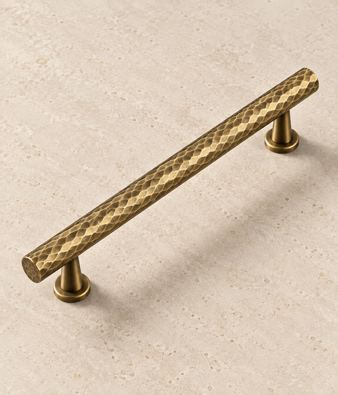 Antique Brass Hammered Cabinet Pulls & Knobs on warm limestone