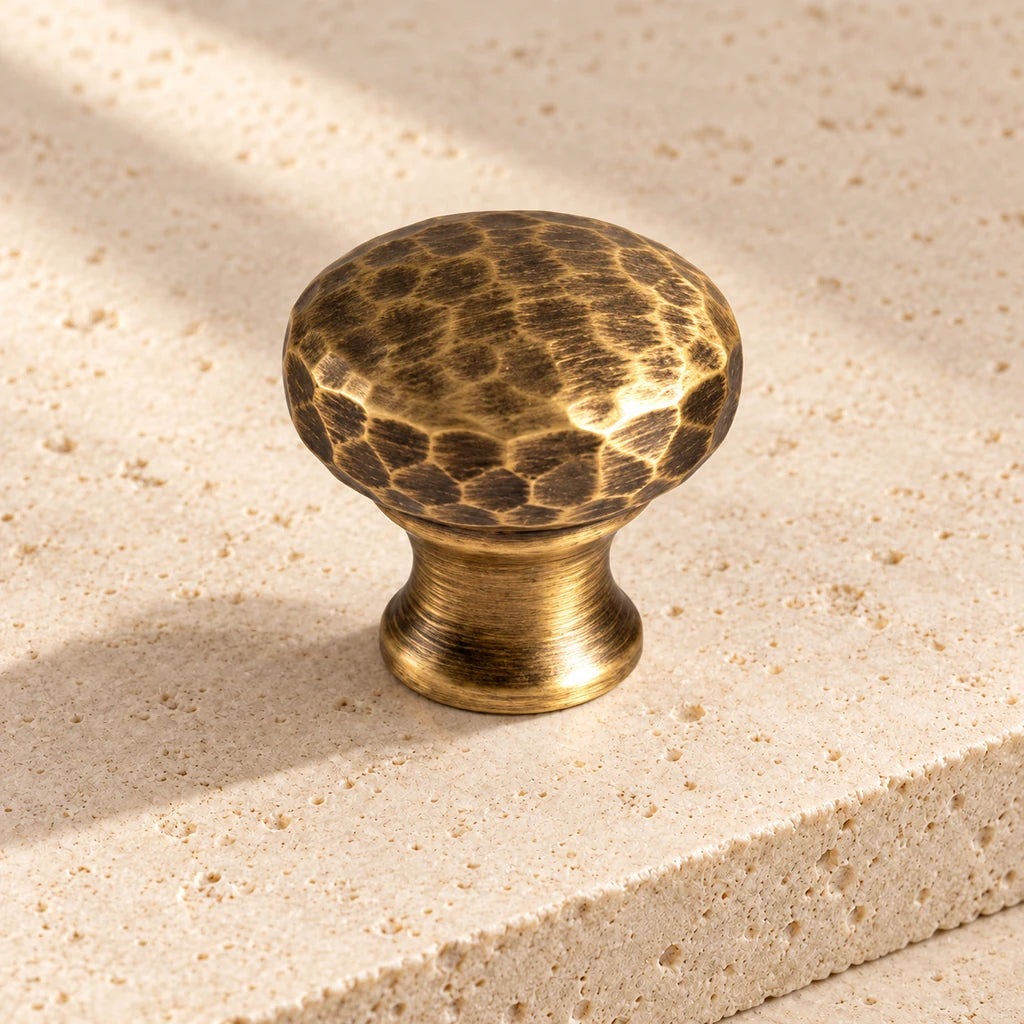 antique brass hammered knob limestone on pale limestone.