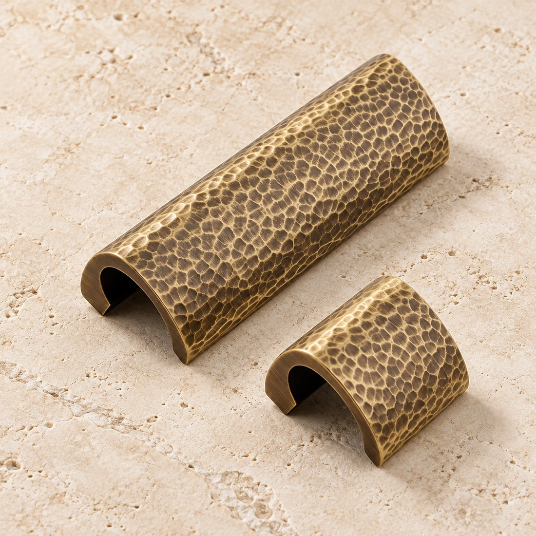 Antique brass hammered semicircle cabinet pulls on ivory limestone