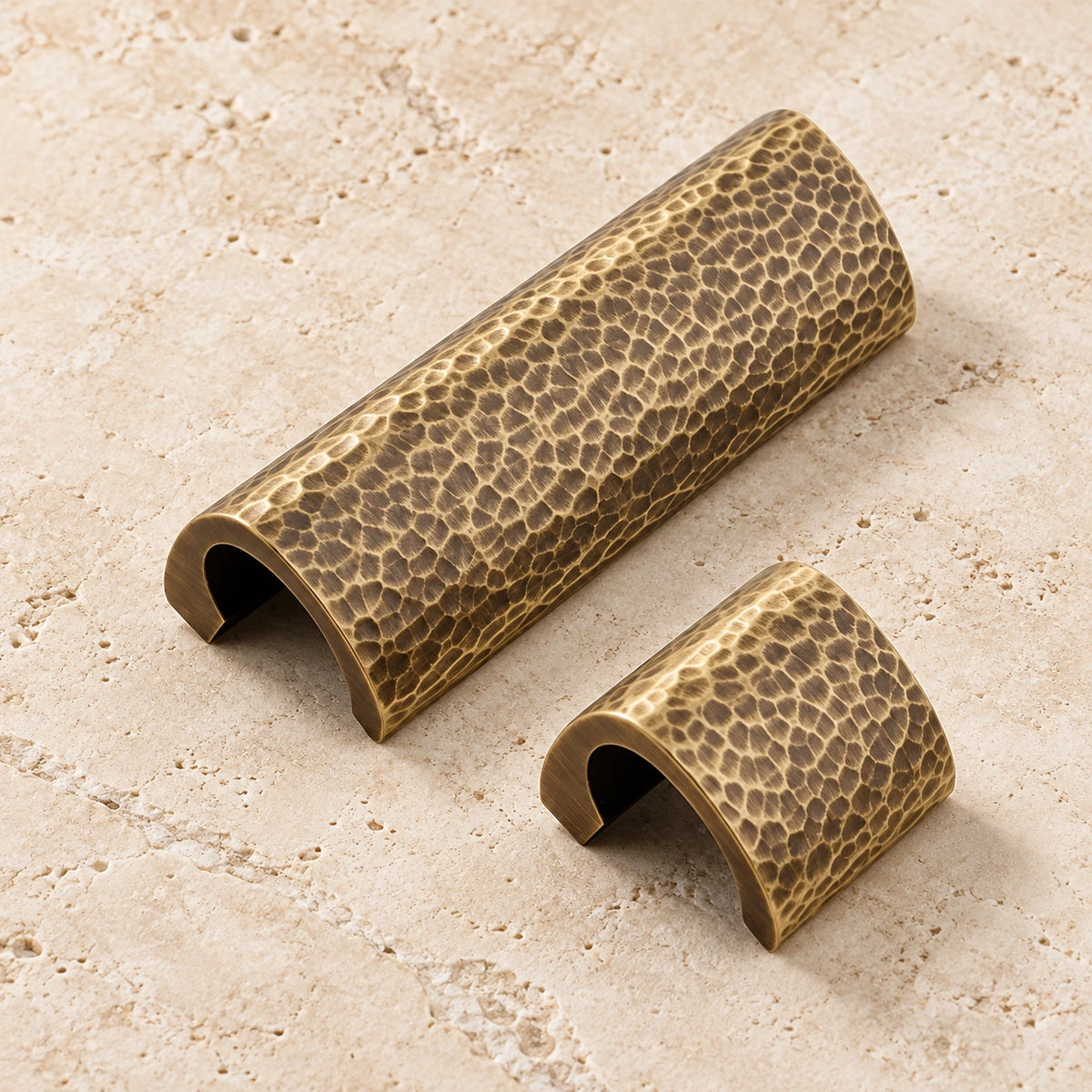 Antique brass hammered semicircle cabinet pulls on ivory limestone