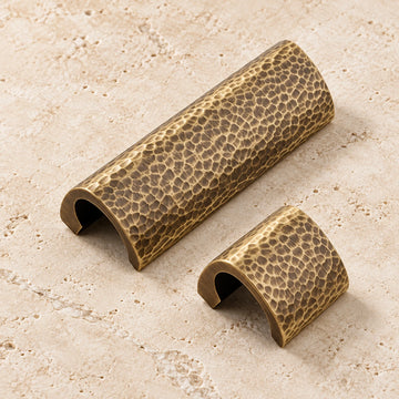 Antique brass hammered semicircle cabinet pulls on ivory limestone