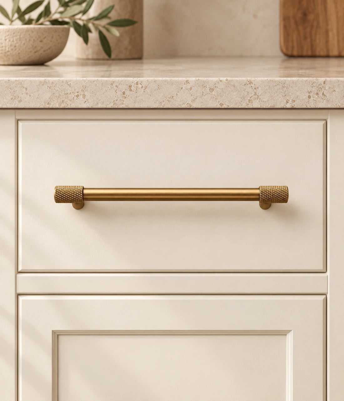 Antique Brass Knurled End Cabinet Bar Pulls on warm limestone