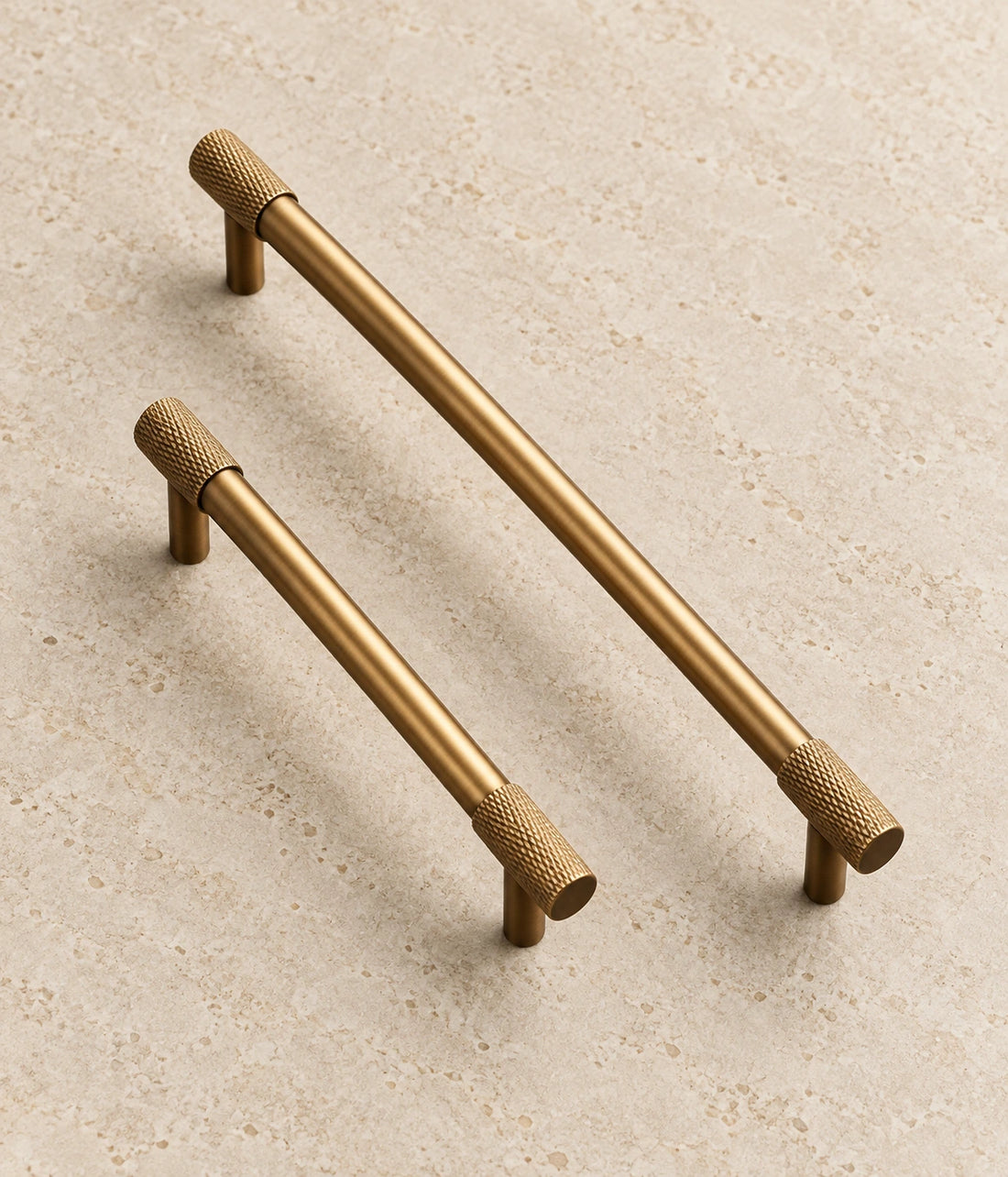Antique Brass Knurled End Cabinet Bar Pulls on warm limestone