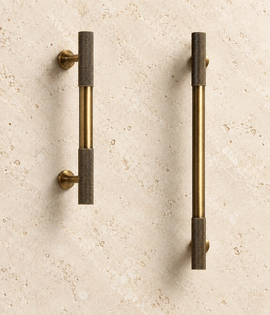 Antique Brass Knurled-End Cabinet Pulls & Knobs arranged on warm limestone