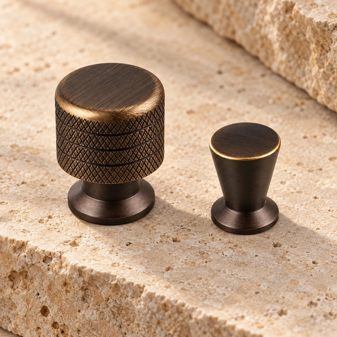 Antique brass knurled and tapered cabinet knobs arranged on limestone