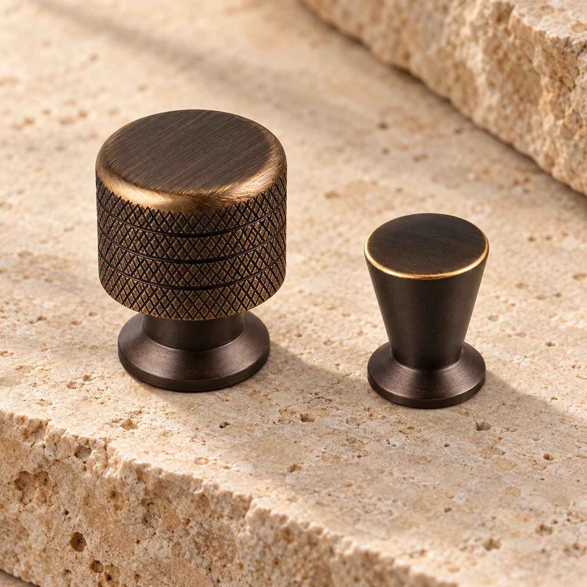Antique brass knurled and tapered cabinet knobs arranged on limestone