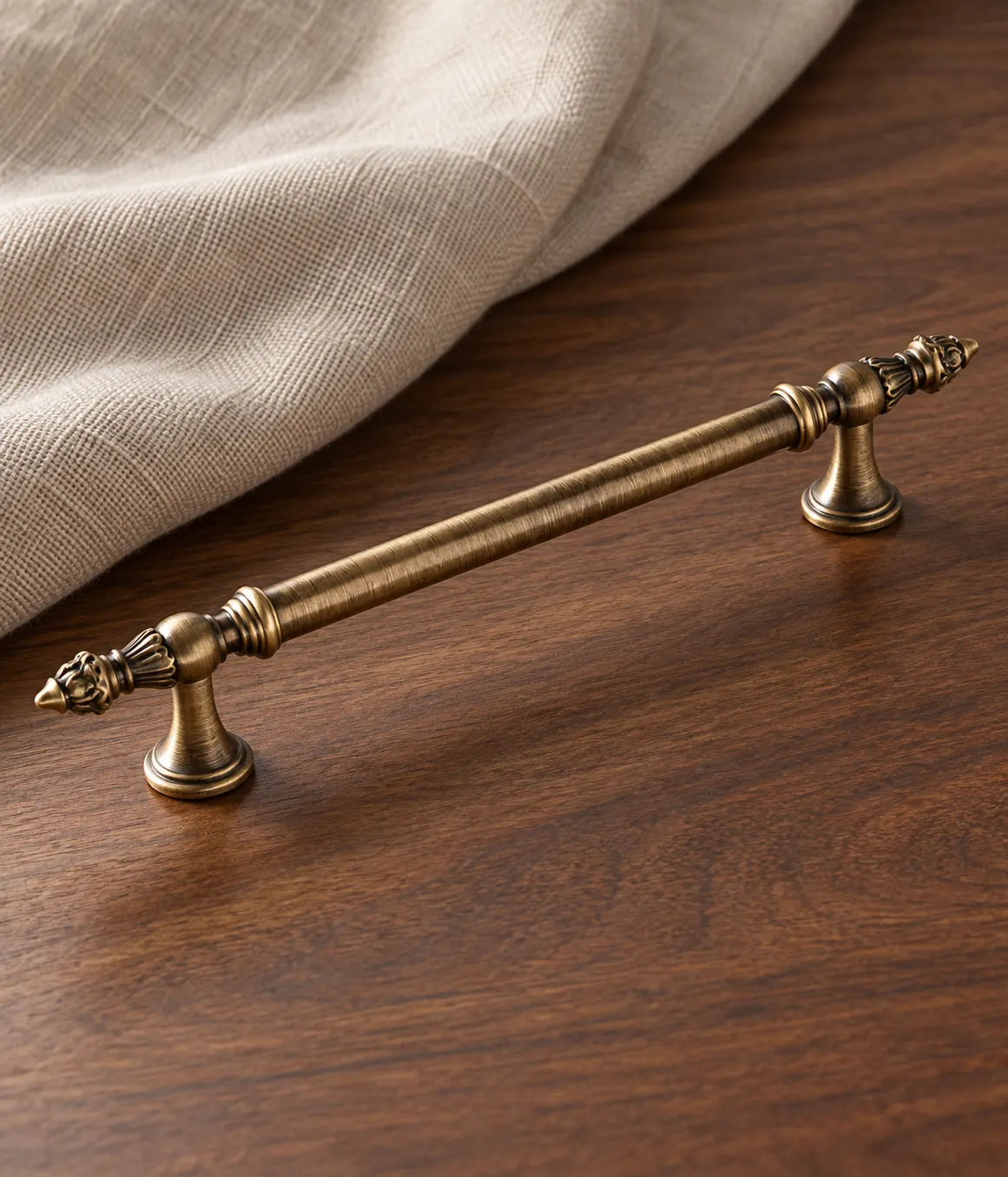 Antique brass leaf-finial cabinet pull on walnut with oatmeal linen