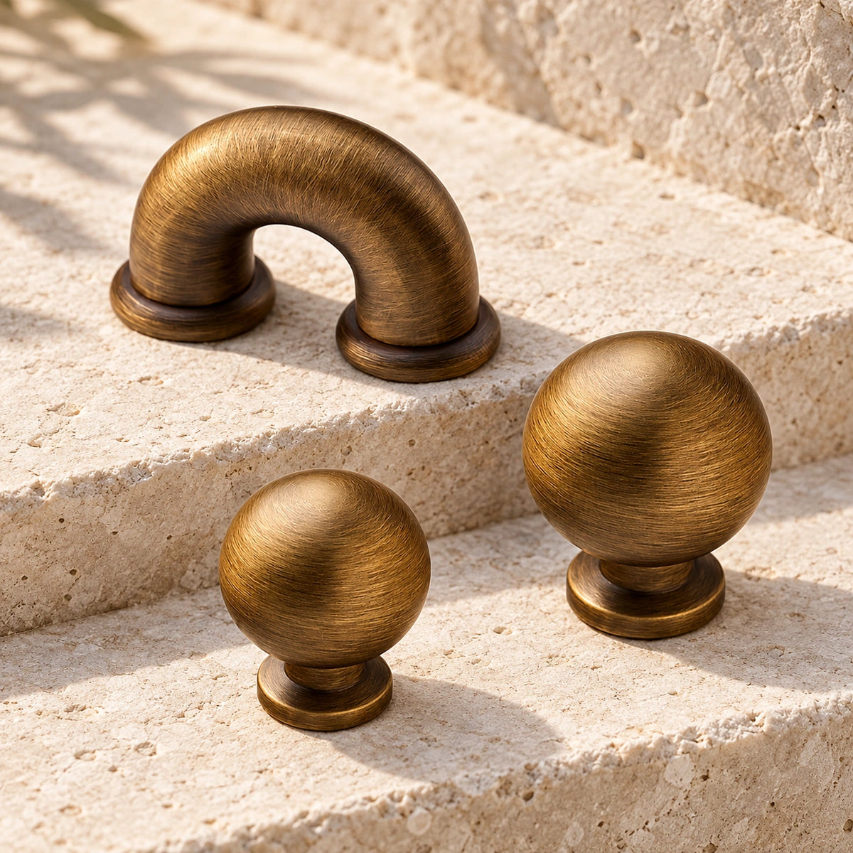 Antique brass mini arch cabinet pull with 25 and 30 mm ball knobs on limestone