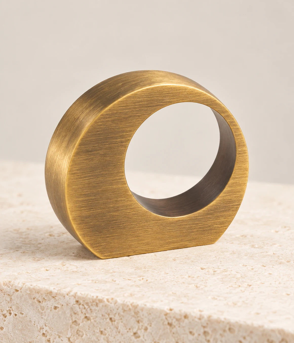 Close view of the brushed antique brass finish and offset opening on the ring pull