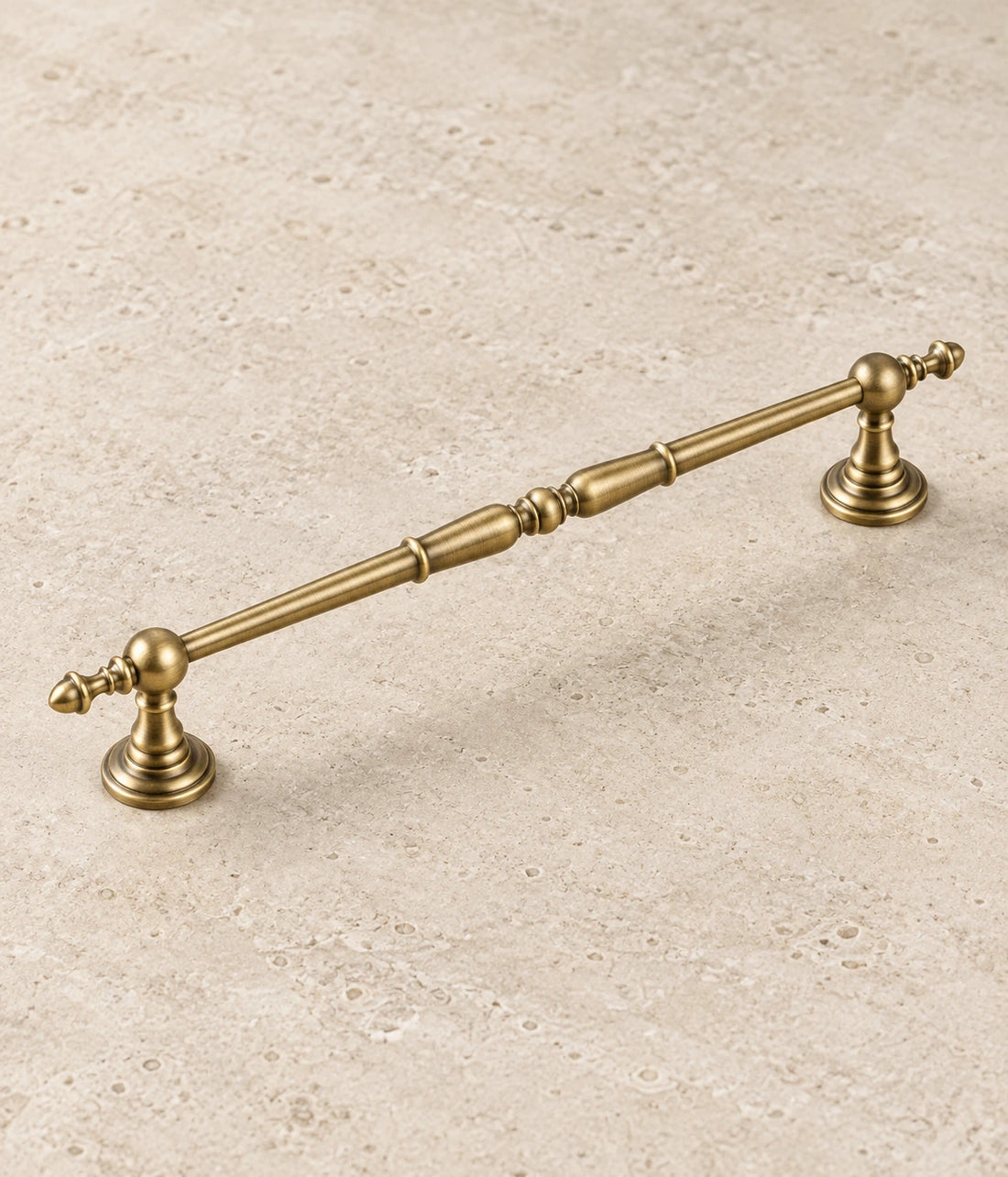 Antique Brass Ornate Spindle Cabinet Pulls on warm ivory limestone