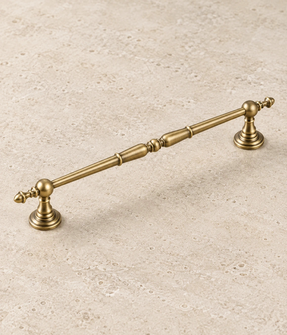 Antique Brass Ornate Spindle Cabinet Pulls on warm ivory limestone