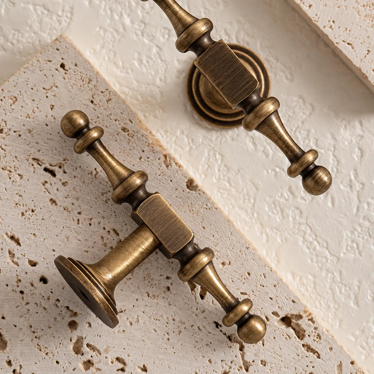 Close-up of ornate antique brass T-knobs with rectangular collars