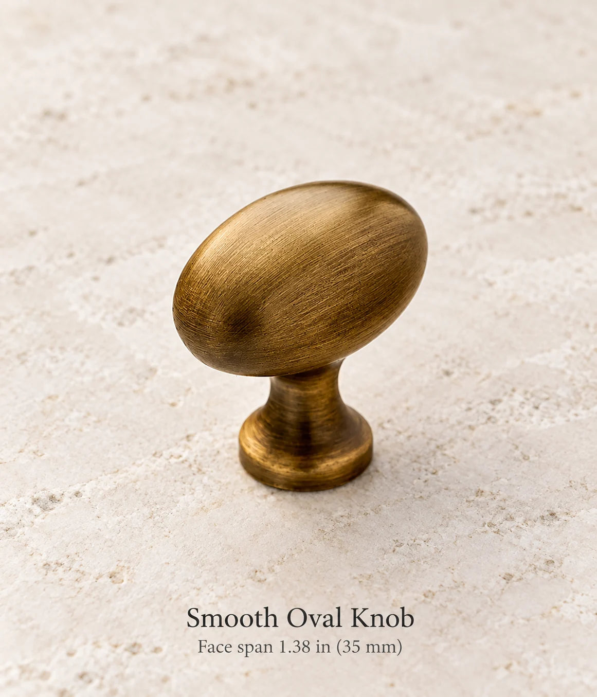 Smooth Oval Knob in antique brass, face span 1.38 in (35 mm)