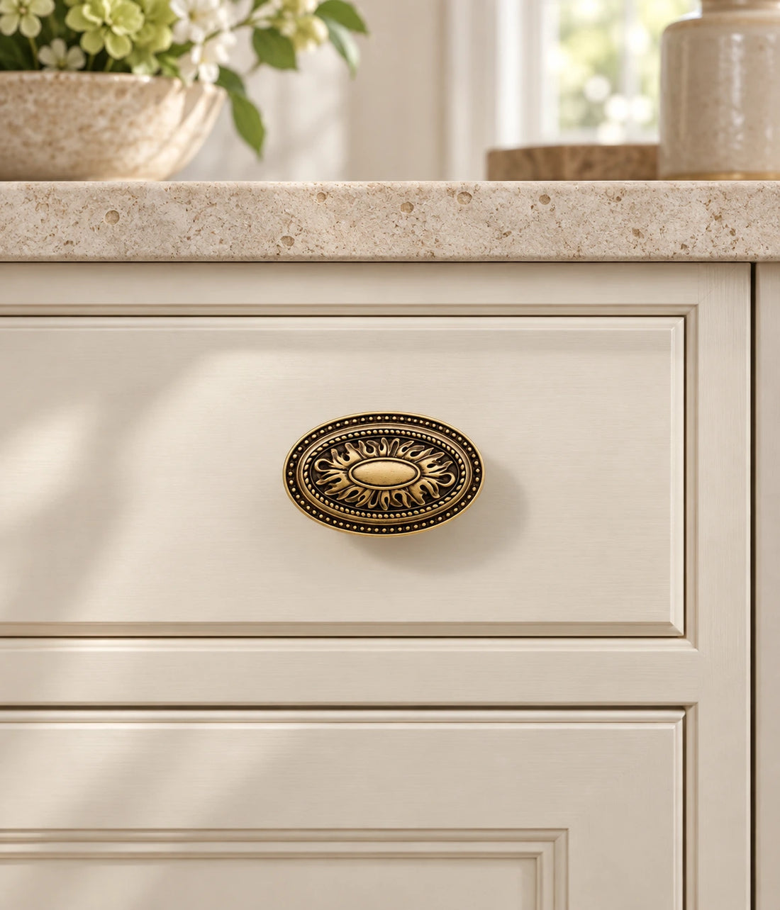 Antique brass oval medallion cabinet knobs in aged patina and brushed styles on limestone