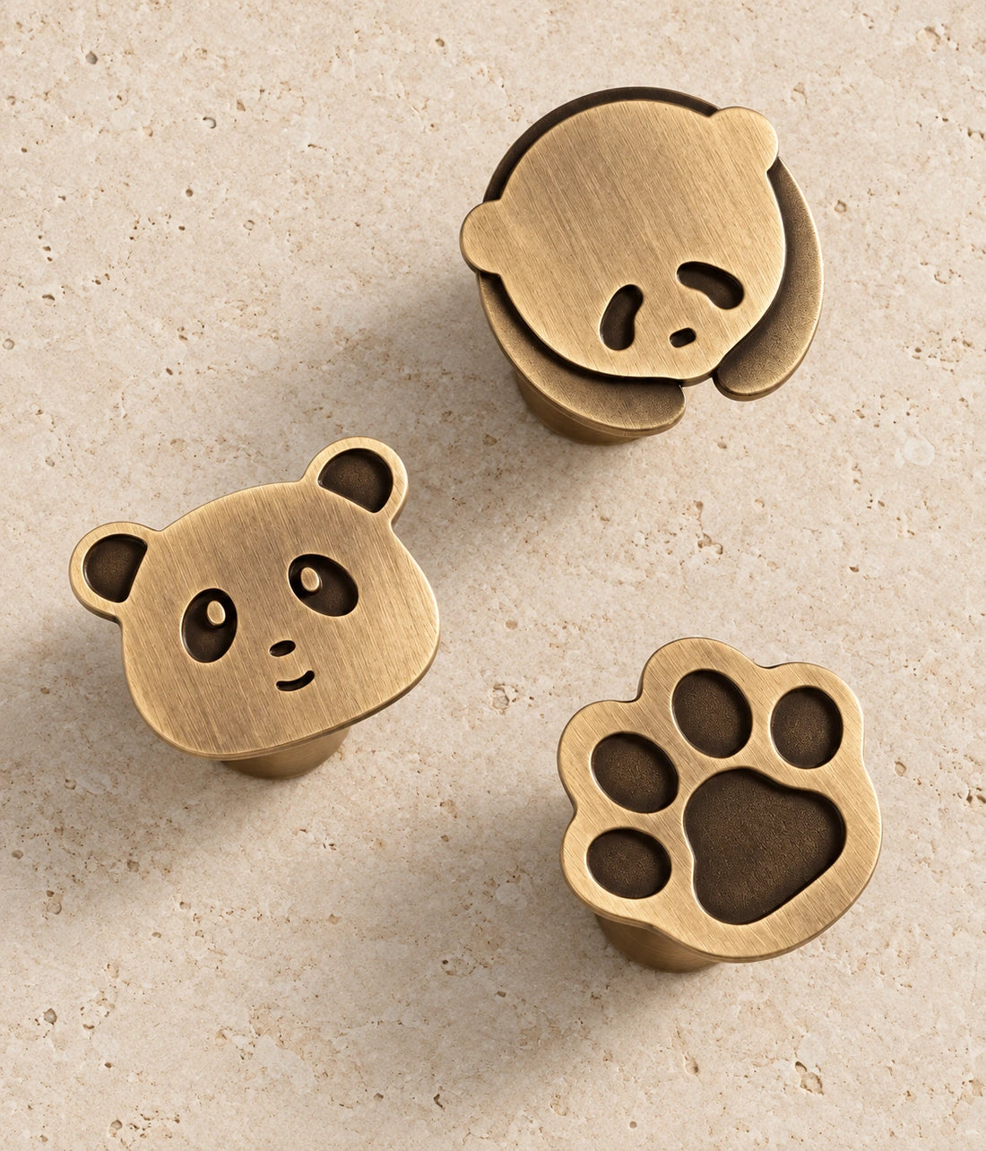 Antique Brass Panda & Paw Cabinet Knobs on warm limestone
