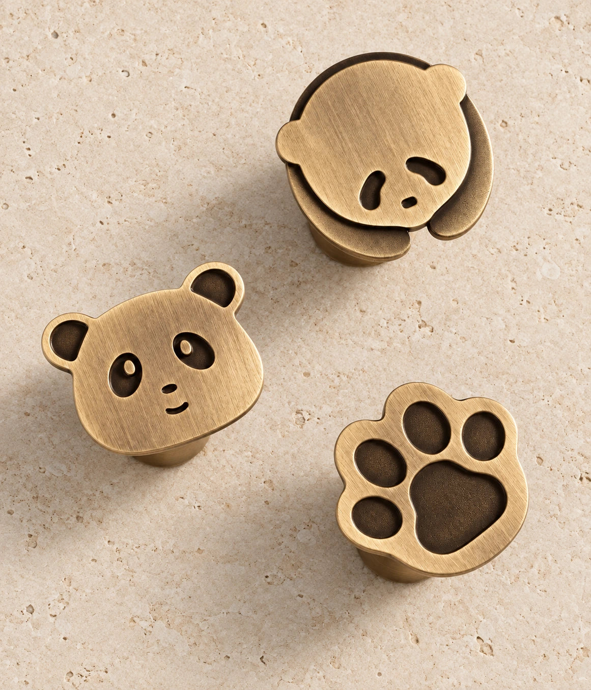 Antique Brass Panda & Paw Cabinet Knobs on warm limestone