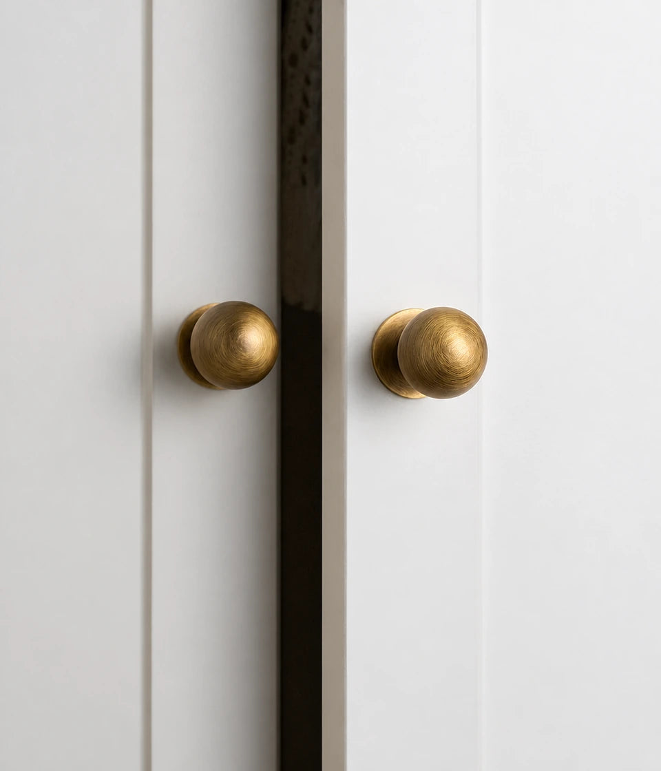 Antique brass ball cabinet knobs mounted on light cabinet doors