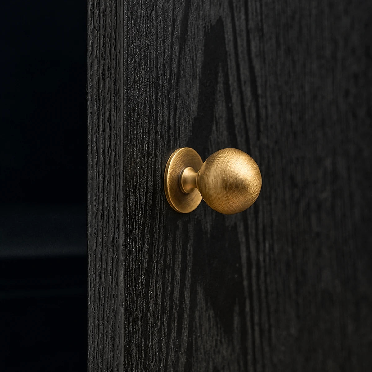 Antique brass pedestal ball knob mounted on dark wood