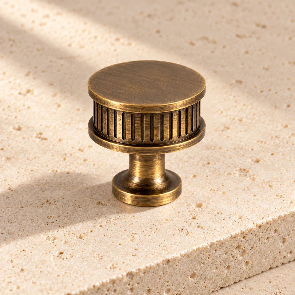 antique brass reeded drum knob limestone on pale limestone.
