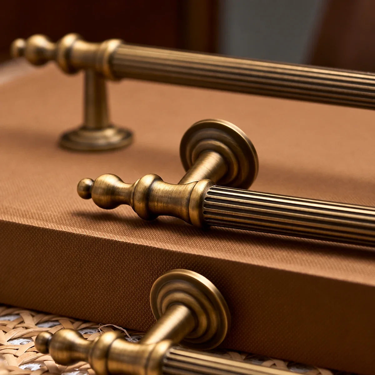 Close-up of reeded grip and turned finials on antique brass cabinet pulls