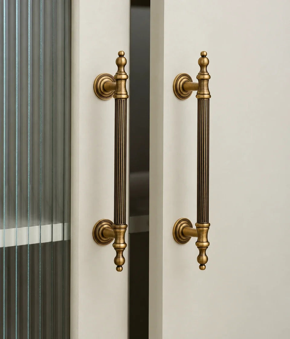 Antique brass reeded finial cabinet pulls installed on glazed cabinet doors