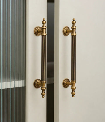 Antique brass reeded finial cabinet pulls installed on glazed cabinet doors
