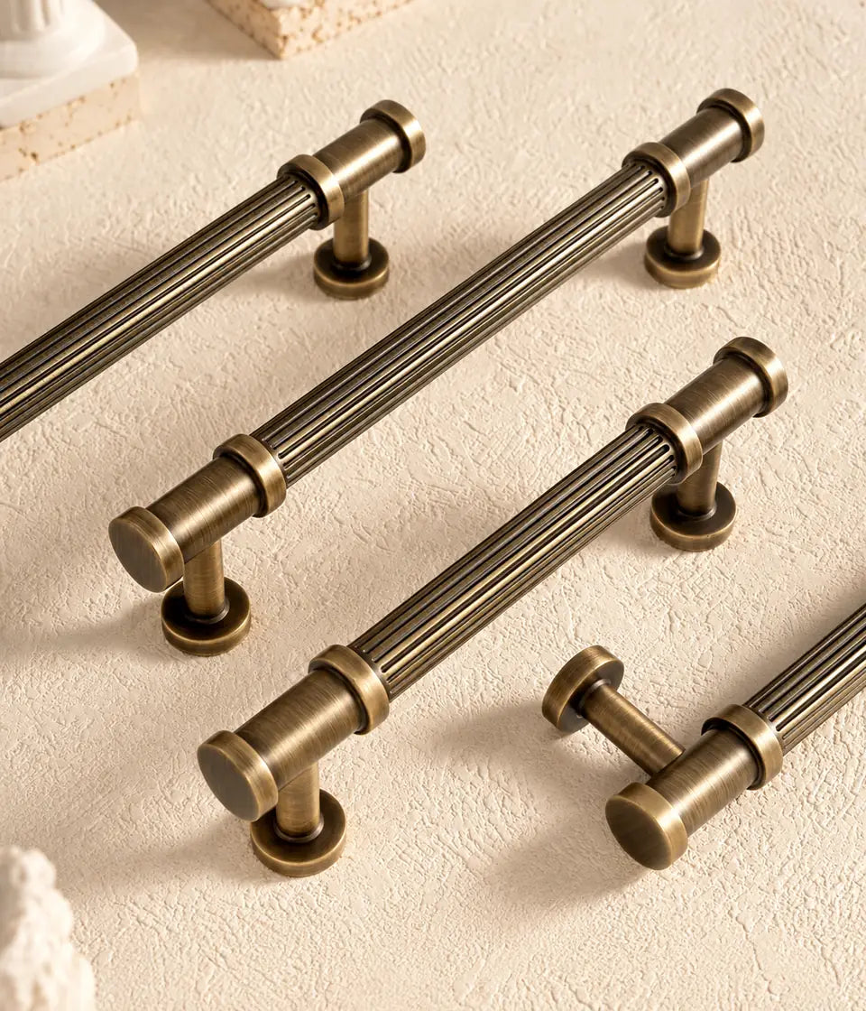 Antique brass reeded cabinet pulls arranged on pale stone