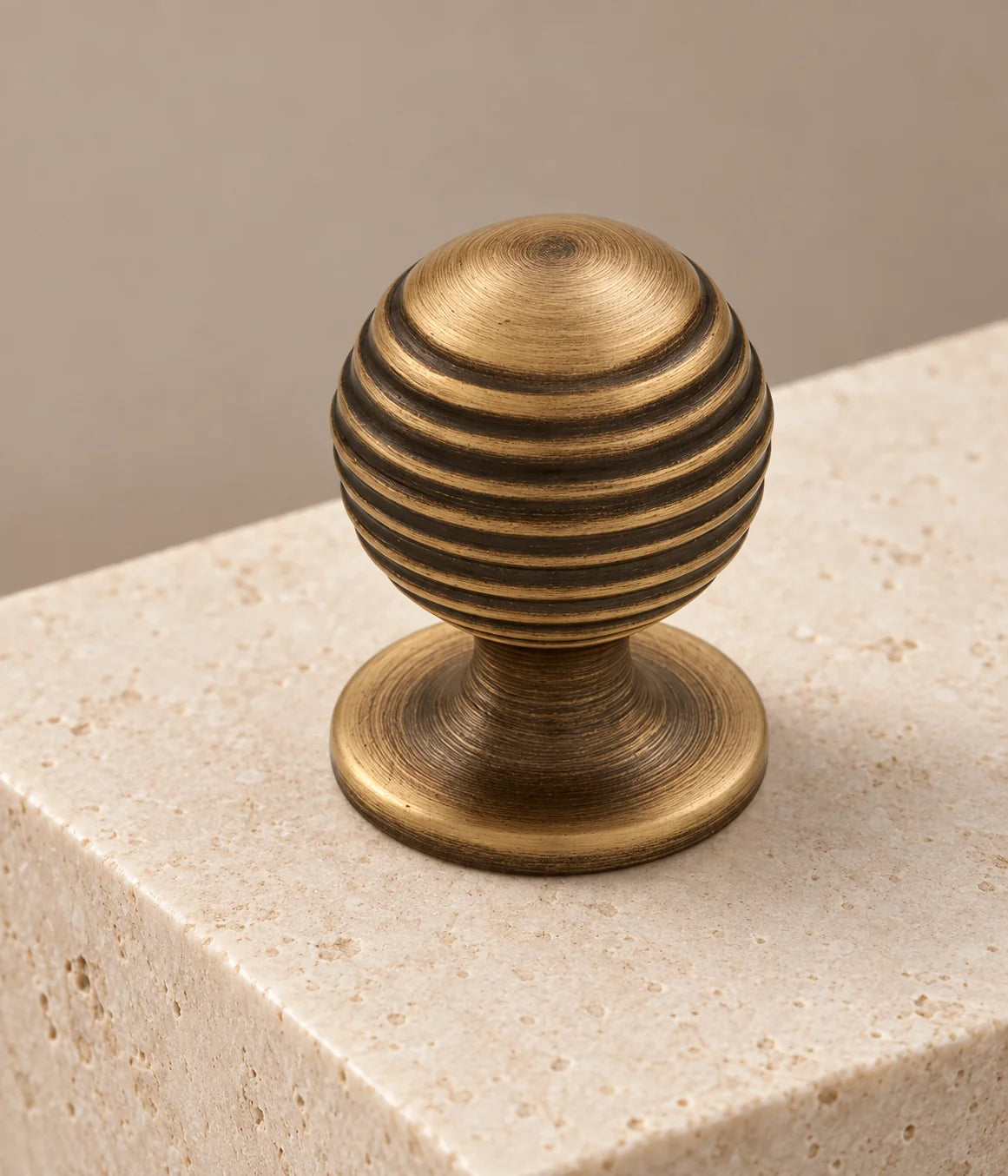 Close view of circular grooves and flared base on an antique brass ball knob