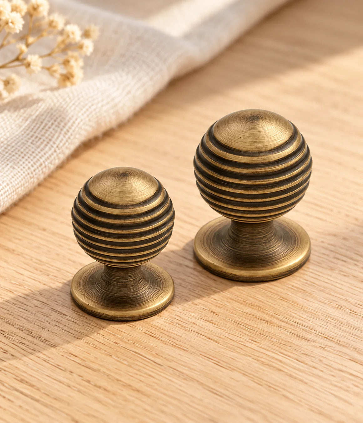 Ribbed brass cabinet knobs styled on pale oak with ivory linen