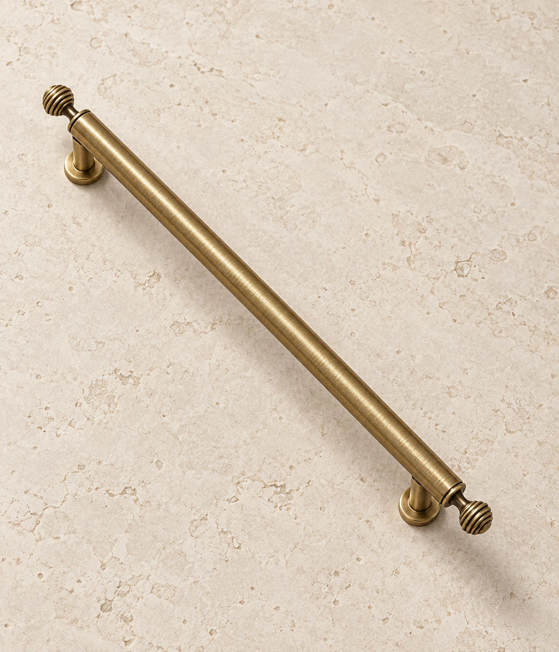 Antique Brass Ribbed-Finial Cabinet Pulls & Knob on warm ivory limestone