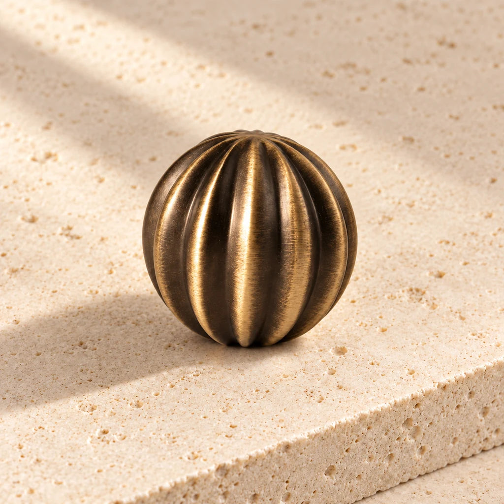 antique brass ribbed finial knob limestone on pale limestone.