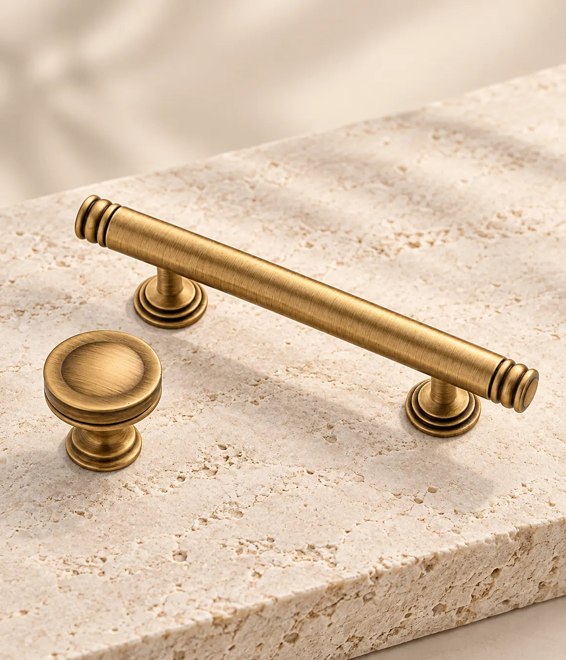 Close detail of smooth brass pull with ringed ends and matching dished knob