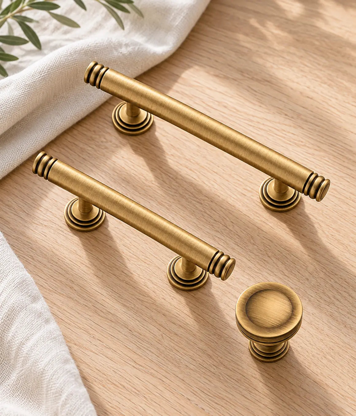 Antique brass ring-end pulls and round knob styled on pale oak and ivory linen
