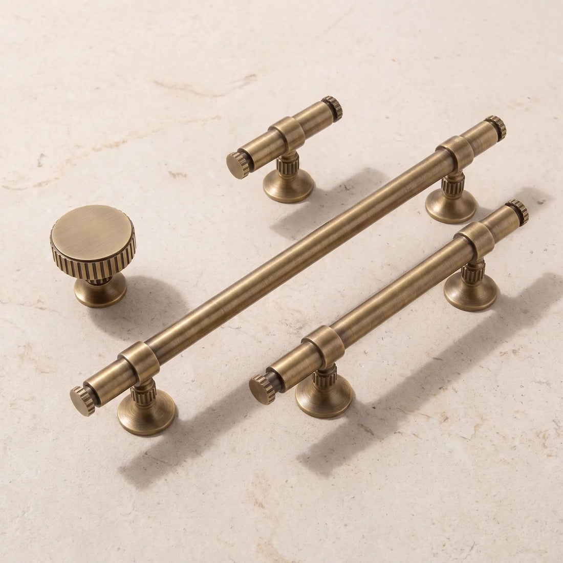 Antique brass ringed cabinet pulls and knobs arranged on limestone