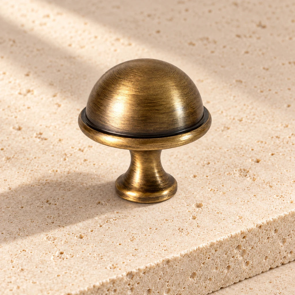 antique brass ringed dome knob limestone on pale limestone.
