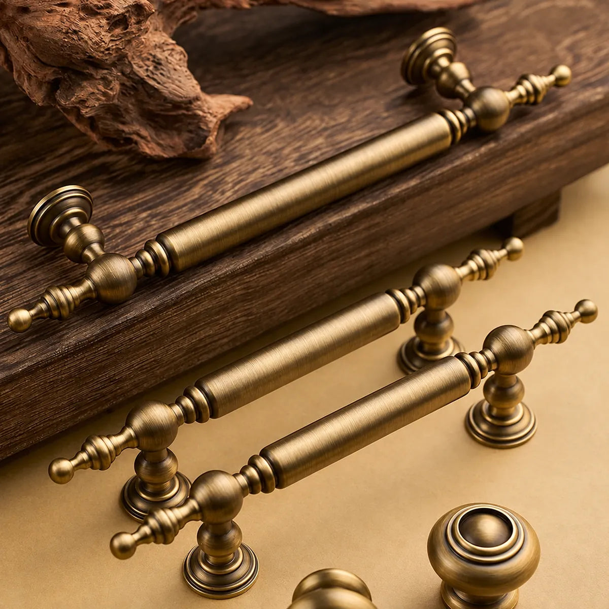 Antique brass ball-finial cabinet pulls and ringed dome knobs on a wood surface