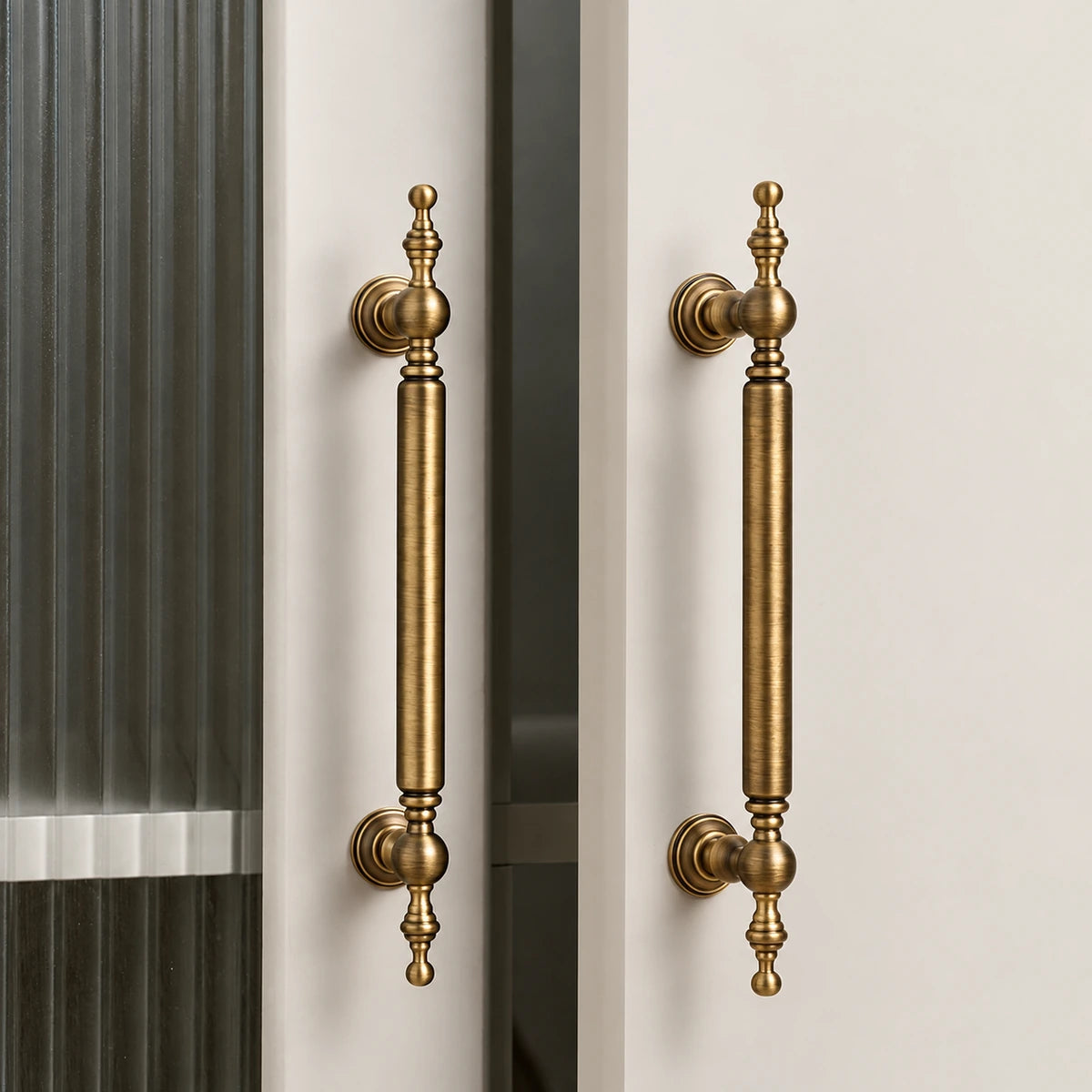 Antique brass ball-finial cabinet pulls installed vertically on glazed cabinet doors